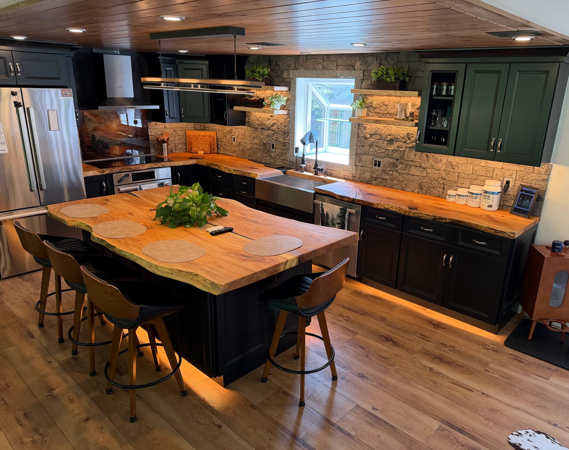 Live edge kitchen island and countertops with green cabinets built by Tougas Timberworks