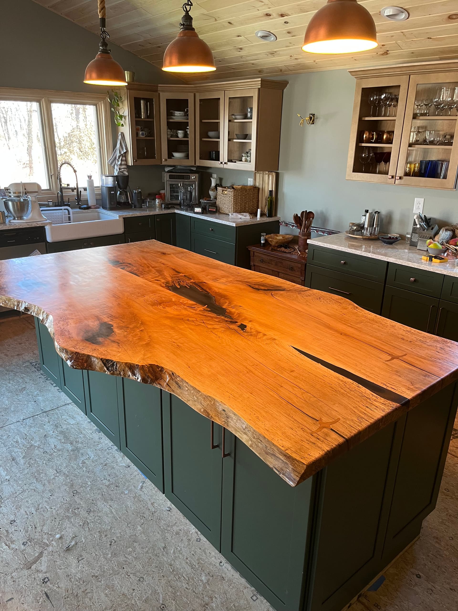Live edge kitchen island with green cabinets built by Tougas Timberworks