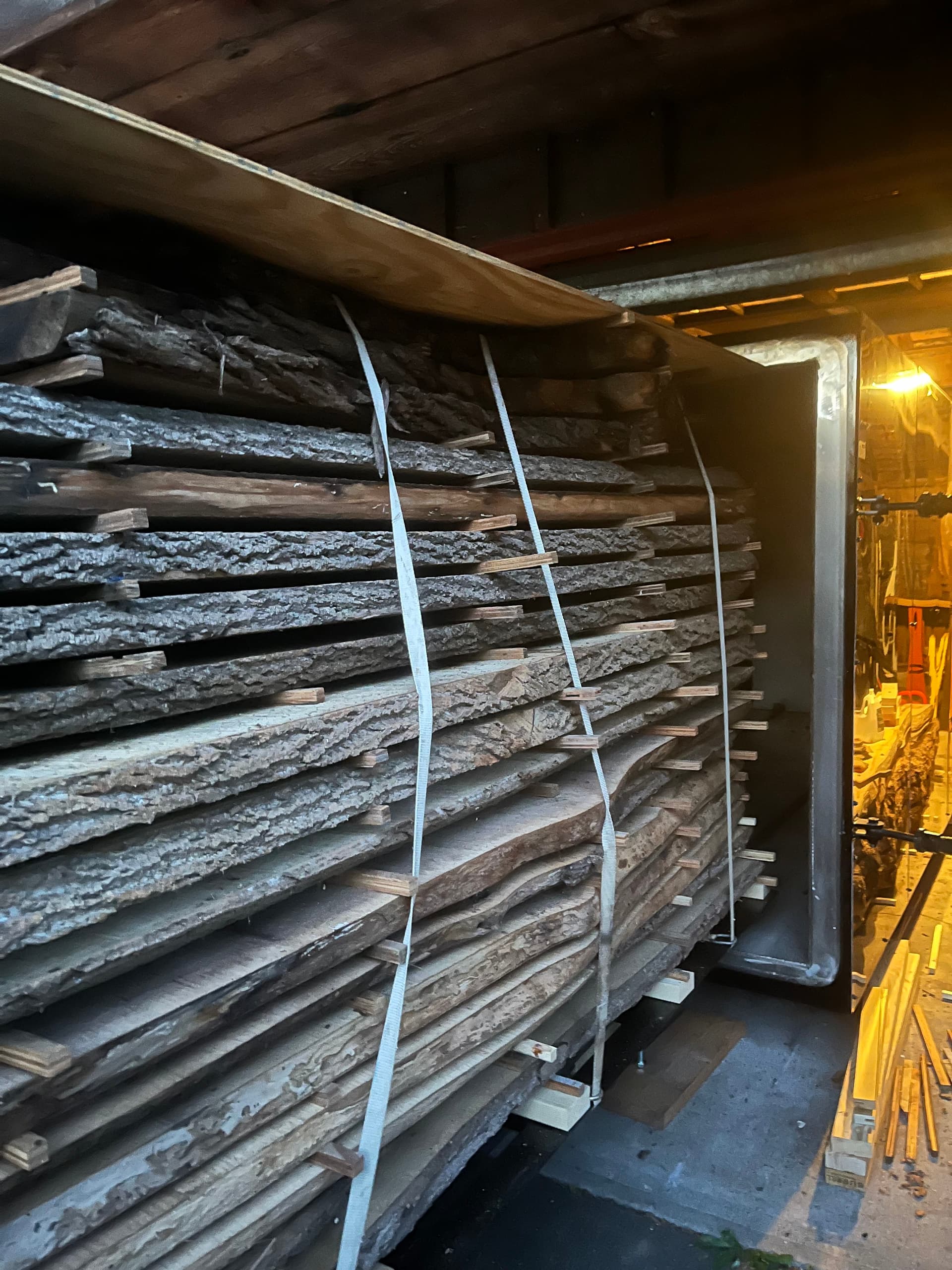 Interior of the kiln at night loaded with lumber on cart, stickers visible between rows